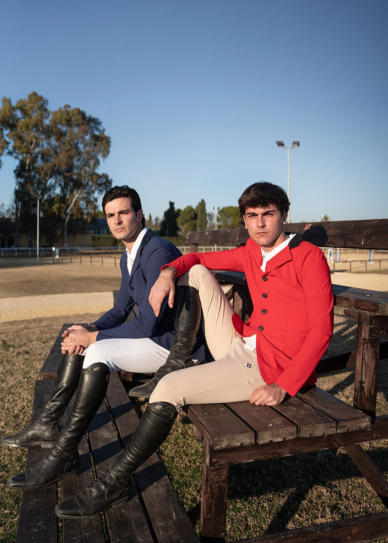 Two men sitting on a wooden bench outdoors with clear blue sky.