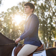 Man riding a horse with trees in the background