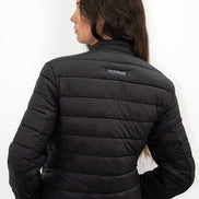 Person wearing a black puffer jacket with a visible brand logo on a white background