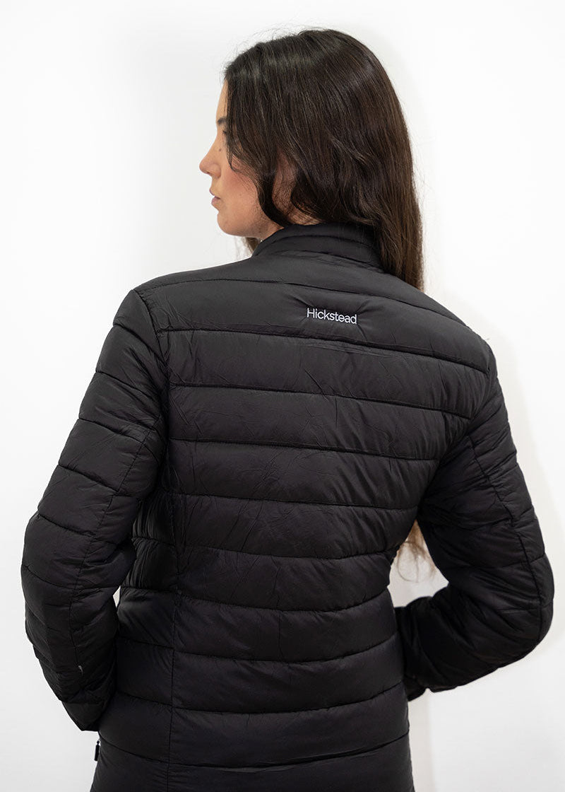 Person wearing a black puffer jacket with a visible brand logo on a white background