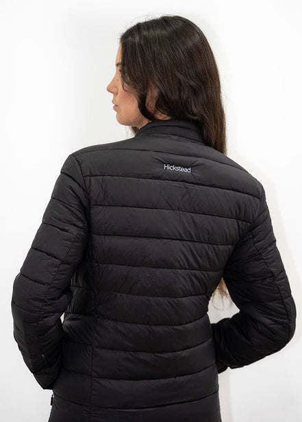 Person wearing a black puffer jacket with a visible brand logo on a white background