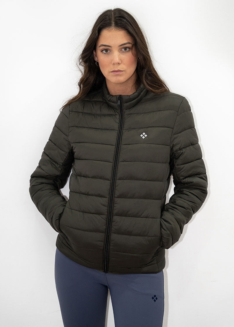 Woman wearing a dark green puffer jacket with a logo on a white background