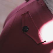Close-up of a pink garment with a button, blurred background