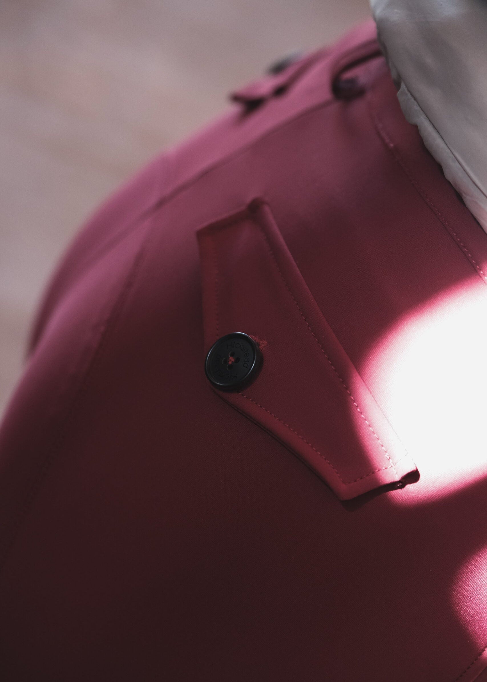 Close-up of a pink garment with a button, blurred background
