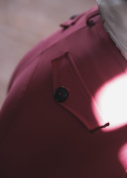 Close-up of a pink garment with a button, blurred background