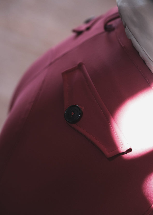 Close-up of a pink garment with a button, blurred background