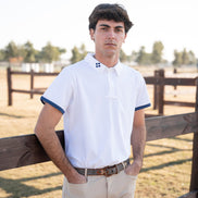 Man standing by a wooden fence in an outdoor setting