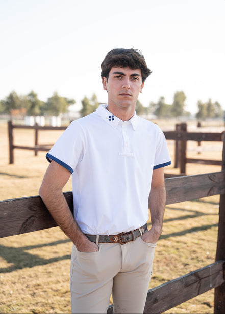 Man standing by a wooden fence in an outdoor setting