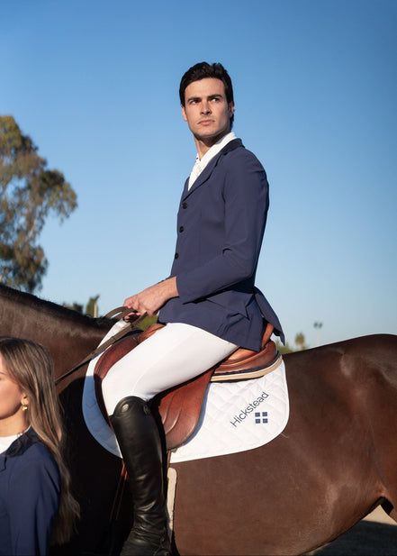 Man riding a horse with a clear blue sky in the background
