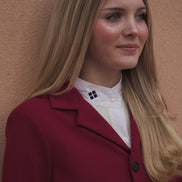Woman wearing a red coat against a beige wall