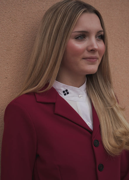 Woman wearing a red coat against a beige wall