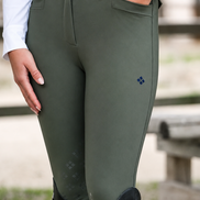 Person wearing green equestrian pants with a blurred background