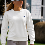 Woman wearing a white sweatshirt and cap on a golf course